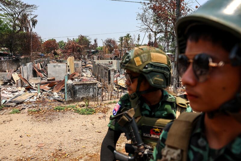 Soldiers from the Karen National Liberation Army patrol in an area hit by a junta airstrike in Myawaddy, April 15, 2024.