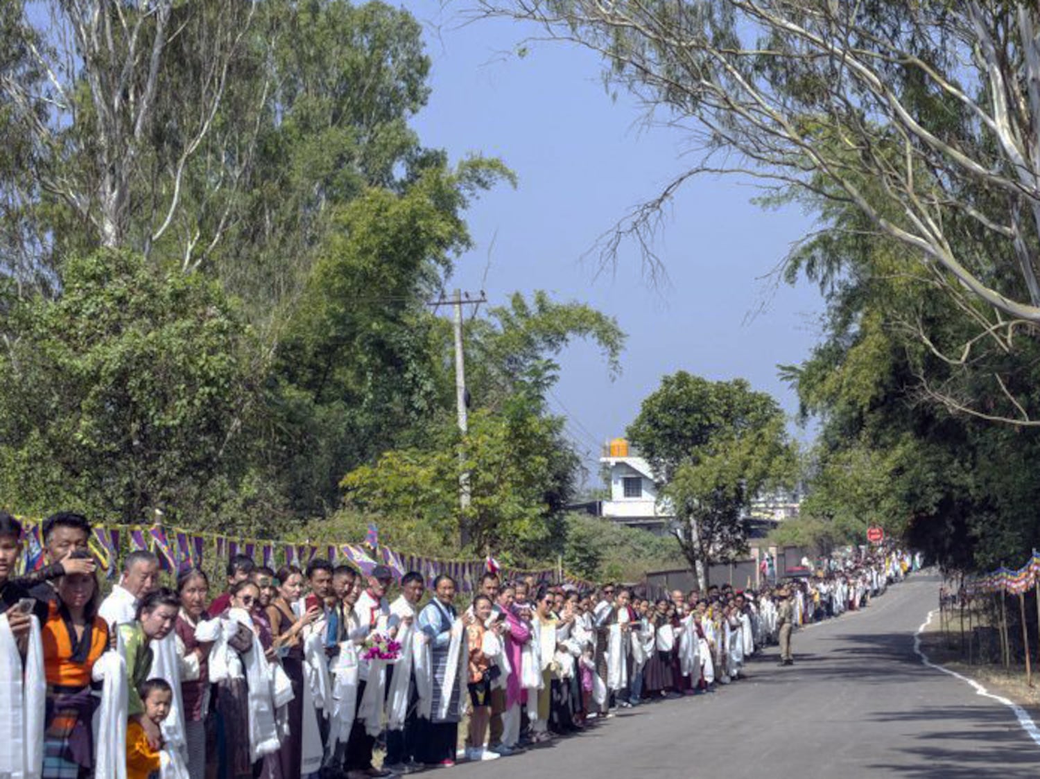 Tausende Tibeter säumen eine Straße in der tibetischen Siedlung Bylakuppe im indischen Bundesstaat Karnataka, um den Dalai Lama zu begrüßen, 5. Dezember 2025.