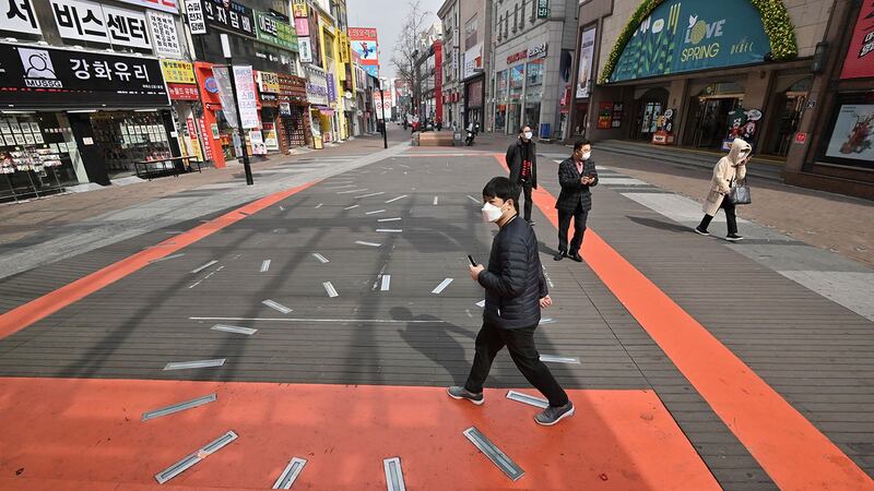  2020年2月21日，戴着口罩的行人在韩国大邱市购物区街道上行走。（法新社） 