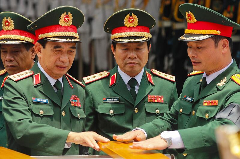 Vietnam's Defense Minister Gen. Phan Van Giang, left, Senior Lt. Gen. Nguyen Tan Cuong, center, chief of the general staff, and officials take part in the state funeral for Nguyen Phu Trong in Hanoi, July 26, 2024. (Minh Hoang/AP)