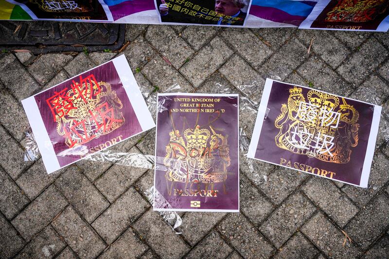 Defaced color photocopies of British National (Overseas) passports are displayed by pro-Beijing activists as they gather outside the British Consulate-General to protest against the use of the British National (Overseas) passport in Hong Kong, February 1, 2021, as a new visa scheme offering millions of Hong Kongers a pathway to British citizenship went live the day before. (Anthony Wallace/AFP)