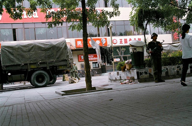 天安门镇压行动之后的六月十日，一名解放军士兵在当时北京唯一的西式快餐店前端枪警戒。(美联社资料图片)