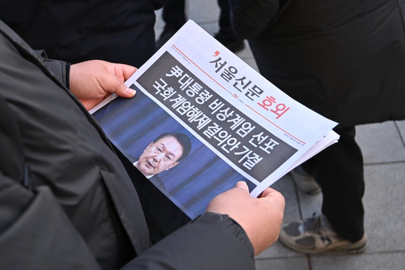 A man reads an extra edition newspaper in downtown Seoul on Dec. 4, 2024, after martial law was lifted.