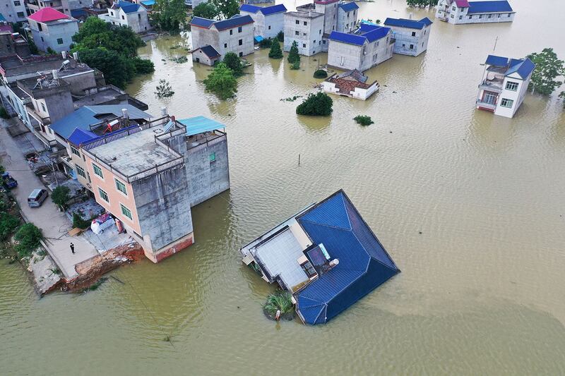 2020年7月13日，江西省鄱阳县鄱阳湖附近的一个村庄，在该地区暴雨之后，洪水淹没的建筑物被部分淹没。（路透社）