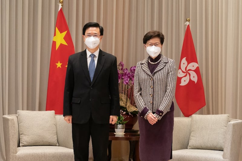 Hong Kong Chief Executive-elect John Lee (L) poses for photos with Chief Executive Carrie Lam during their meeting at the Central Government Complex ahead of a press conference in Hong Kong, May 9, 2022. Credit: AFP