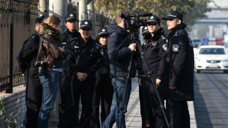 图为在北京第三中级法院外的外国记者遭当局人员赶走。 （AFP）