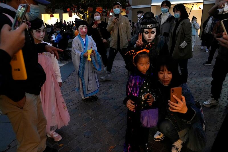 一群北京居民30日晚间以各种鬼魅扮相于万圣节前夕在街头出游。(美联社)