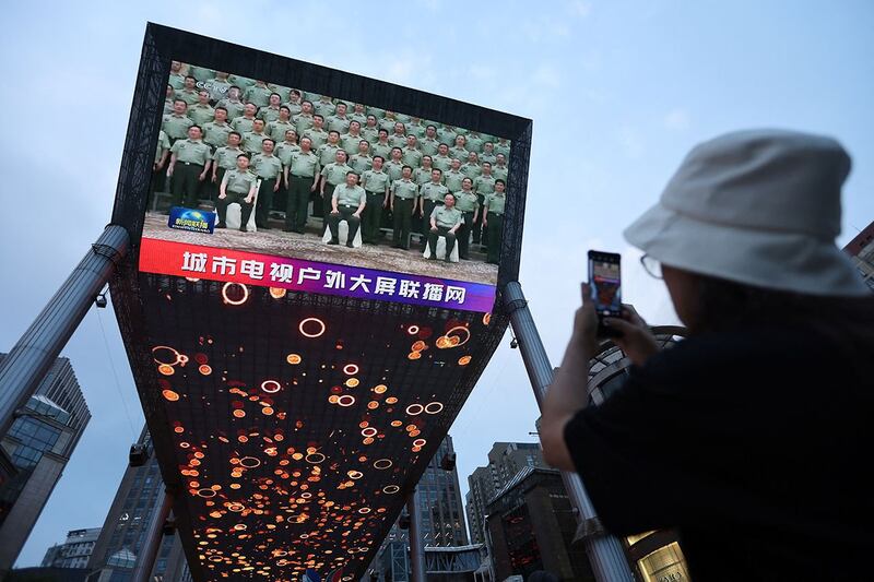 2022 年 7 月 15 日，在北京的一个购物中心，巨大屏幕播放中国国家主席习近平访问新疆维吾尔自治区的新闻片段。（路透社）