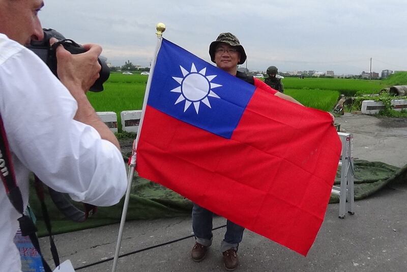 来自台北的吴启豪，就带着巨幅青天白日旗到现场制高点，引发法国媒体费加洛报拍摄。（记者夏小华摄）