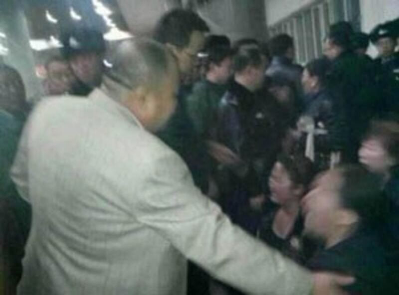 Government officials and Public Security personnel confront herders at the train station in Hohhot, March 1, 2013.