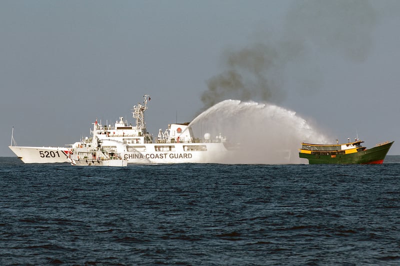 Chinese Coast Guard vessels fire water cannons towards a Philippine boat, right, as it sailed on a resupply mission to a Philippine military outpost at Second Thomas Shoal in the South China Sea, March 5, 2024.