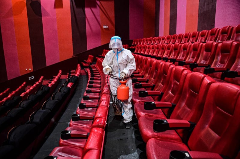 A staff member sprays disinfectant at a cinema as the city starts to reopen after a Covid-19 coronavirus outbreak in Shenyang, in China's northeastern Liaoning province, April 25, 2022. Credit: AFP