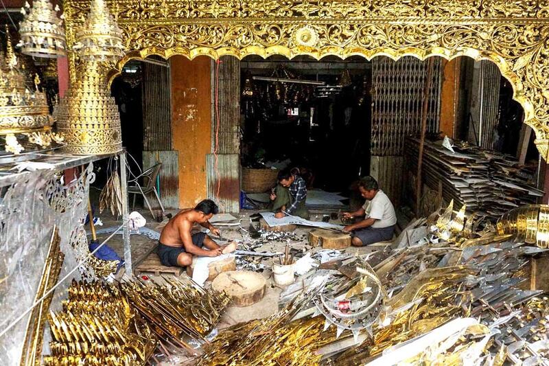 Craftsmen ply their trade at a casting workshop in Kyimyindaing, Yangon Region. Bronze handicrafts such as Buddha images, finials, crowning ornaments, bells, gongs and other figures are most often used in pagodas and temples. (Myo Min Soe/RFA)