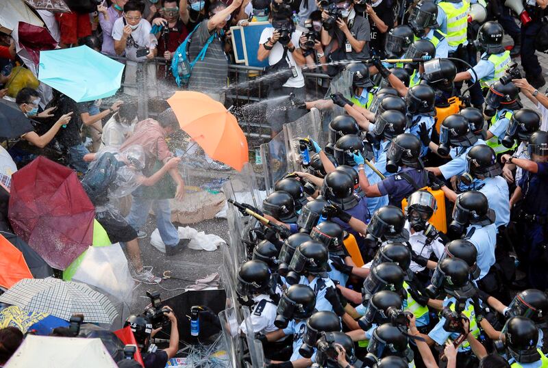 Riot police use pepper spray against protesters after thousands of people block a main road to the financial central district outside the government headquarters in Hong Kong, Sept. 28, 2014. (Vincent Yu/AP)