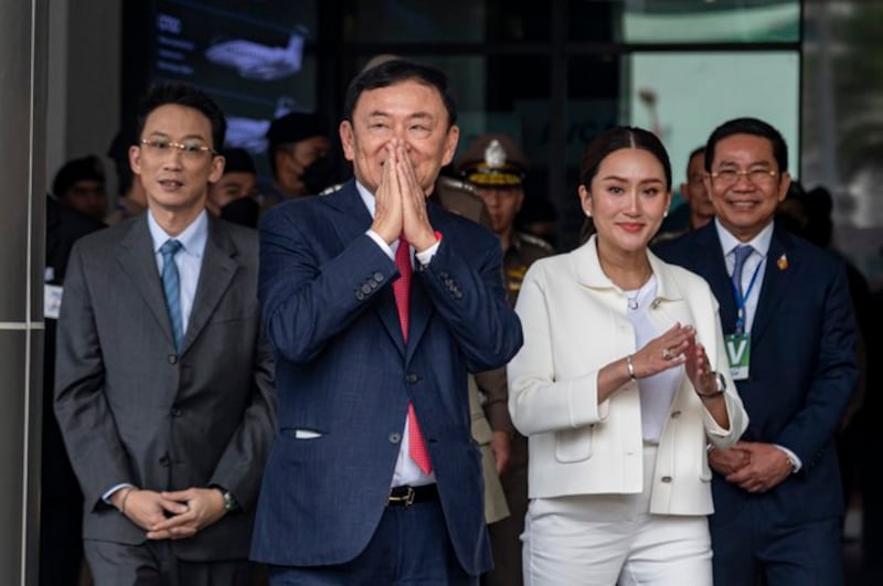 Former premier Thaksin Shinawatra, alongside his son, Panthongtae, and daughter, Paetongtarn, greets supporters after arriving at Mjets private terminal at Don Mueang International Airport in Bangkok, Aug. 22, 2023. Credit: Thai News Pix/BenarNews