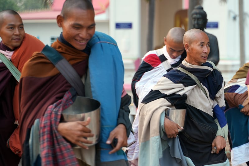 Vietnamese monk Thich Minh Tue, right, walks during alms rounds in Nong Bua, Nakhon Sawan province, Thailand, Feb. 13, 2025.