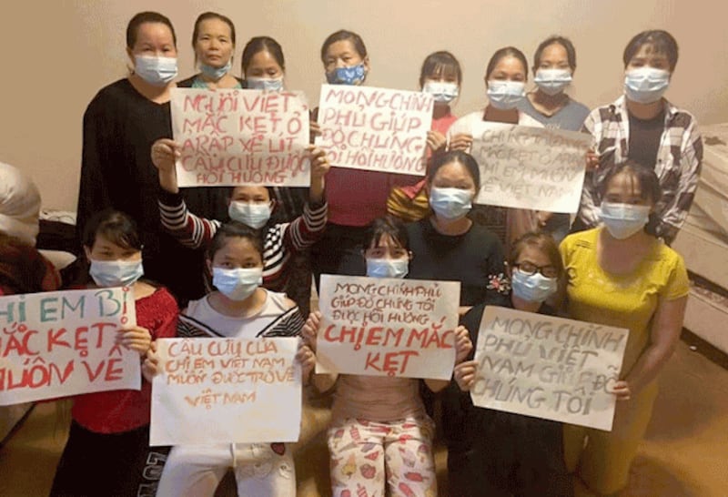 Vietnamese women who work as domestic helpers in Saudi Arabia hold signs asking the Vietnamese government for help in an undated photo. Photo courtesy of BPSOS/CAMSA International