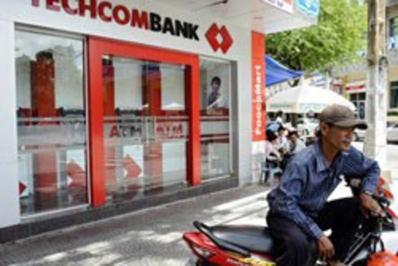 Một lái xe ôm chờ khách bên ngoài Ngân hàng Techcombank, một trong những ngân hàng thương mại cổ phần lớn ở Việt Nam. Ảnh chụp hôm 30/5/2012. AFP photo 