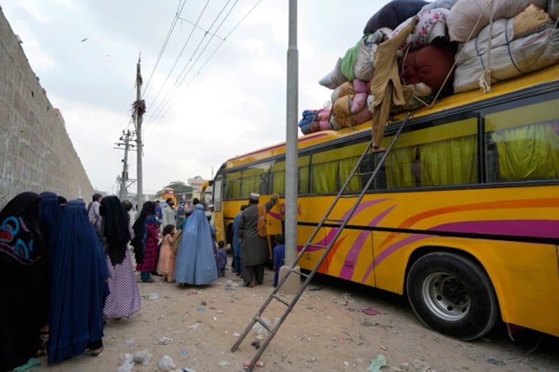 Afghan families board a bus to depart for their homeland, in Karachi, Pakistan, October 2023. Pakistan's government announced a major crackdown on migrants in the country illegally, saying it would expel them starting next month and raising alarm among foreigners without documentation that include about 20 Uyghur families. Credit: Fareed Khan/AP