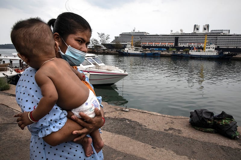 A woman carries a baby by the waterside in Sihanoukville, Cambodia, on Feb. 17, 2020. (Paula Bronstein/Getty Images)