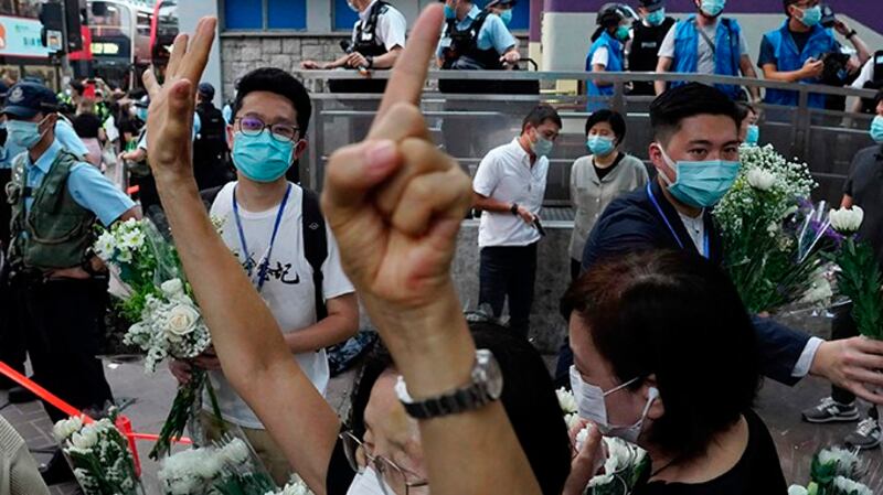 2020年8月31日，一名民众在香港地铁太子站外打出了“五大诉求缺一不可”的手势。（美联社）