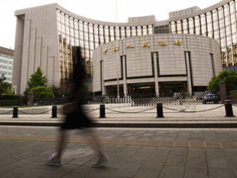 A pedestrian walks past the headquarters of the People's Bank of China (PBOC), China's central bank, in Beijing, May 4, 2016.