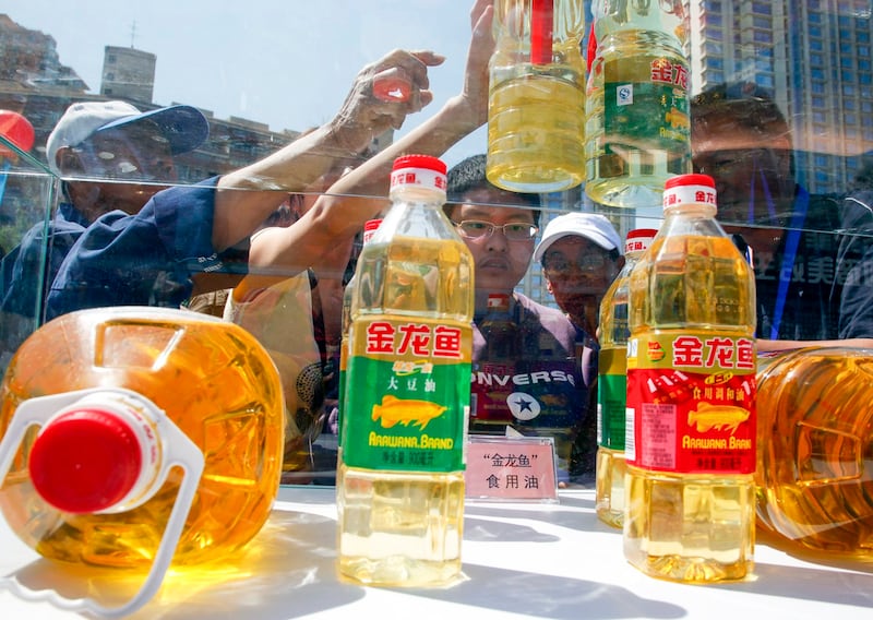 Chinese residents try to tell counterfeit cooking oil products from the real products during an event to promote awareness of economic crimes in Beijing, China, May 15, 2011. (Ng Han Guan/AP)