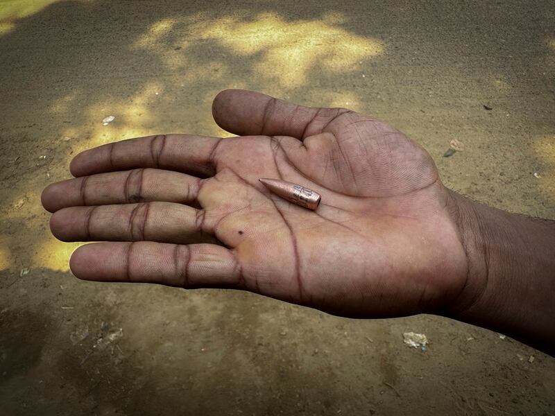 A Bangladeshi boy displays a bullet, allegedly shot from Myanmar during fighting between Myanmar security forces and Arakan Army, in Ghumdhum, Bangladesh, on Feb. 5, 2024. (Shafiqur Rahman/AP)