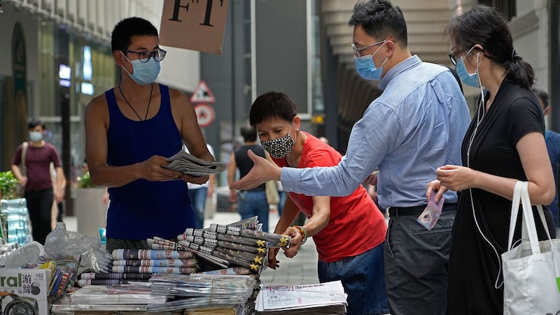 2021 年 6 月 18 日，人们在香港市中心的街道上购买 《苹果日报》。 （美联社）