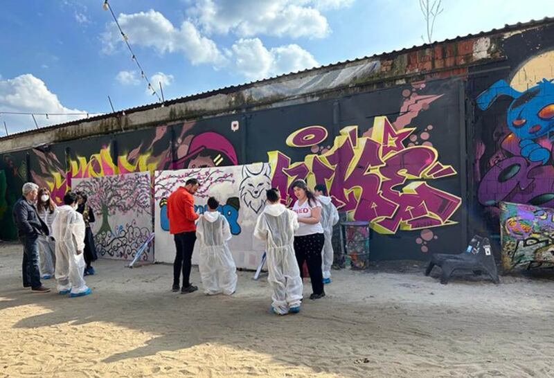 Uyghur children paint banners next to a remnant of the Berlin Wall in Germany's capital Berlin, April 10, 2023. Credit: Semet Abla