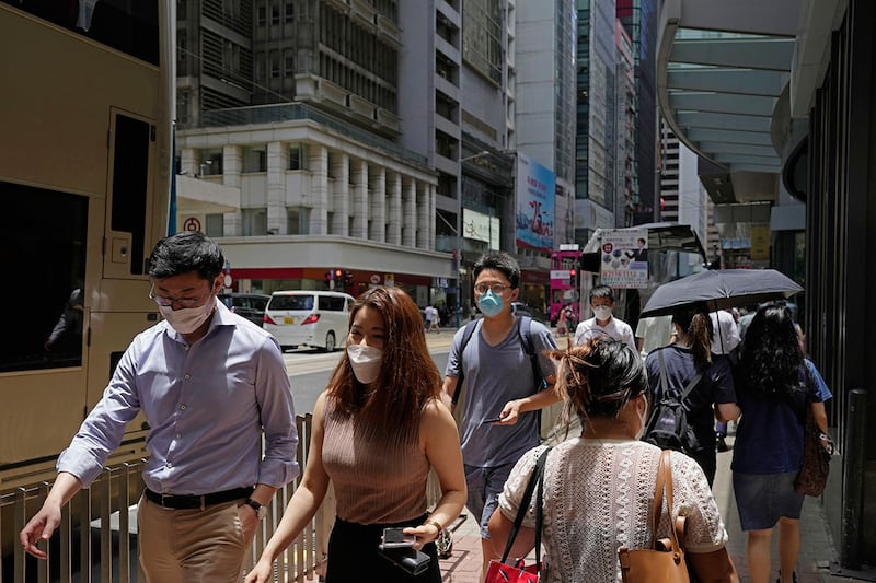 2022年7月12日，人们戴着口罩走在香港的一条街道上。（美联社）