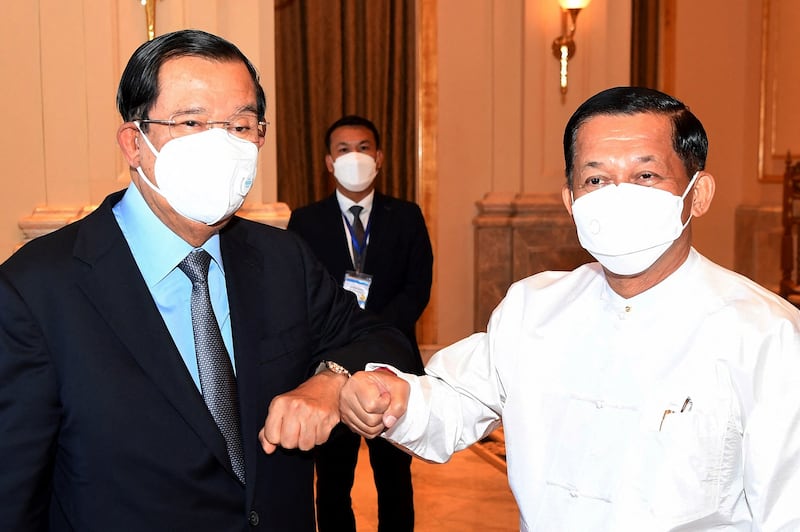 This handout photo taken and released by National Television of Cambodia (TVK) on Jan. 7, 2022 shows Cambodia's Prime Minister Hun Sen (L) greeting Myanmar military chief Min Aung Hlaing during a meeting in Naypyidaw. AFP/National Television of Cambodia