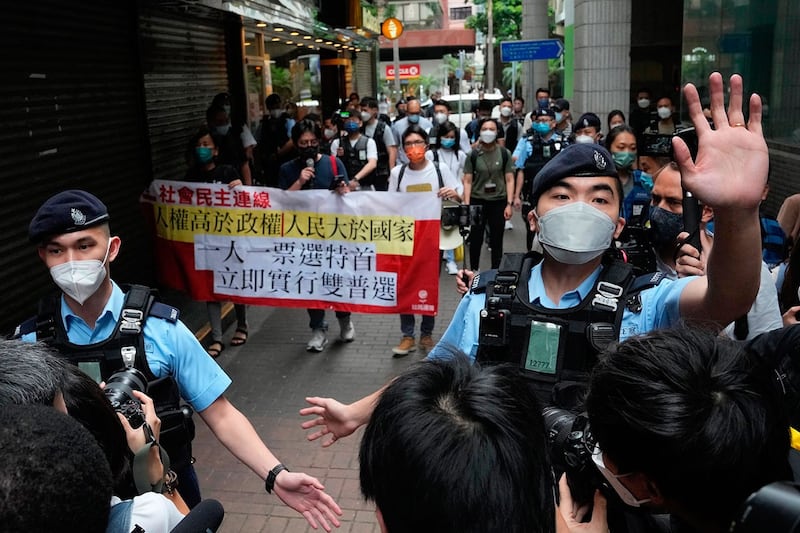 2022 年 5 月 8 日，香港社民连举着反对特首选举的横幅时被警察包围。（美联社）