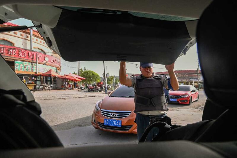 A security guard checks a car to gain entry to a gas station on the outskirts of Yarkant in northwestern China's Xinjiang region. Houses that were once home to people who went missing in China's crackdown on its Muslim minorities stand locked and silent in Xinjiang's rural heartland. Credit: Pedro PARDO / AFP