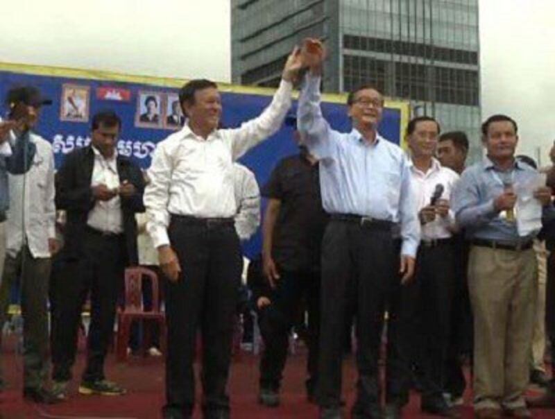 CNRP President Sam Rainsy (r) and deputy chief Kem Sokha (l) address supporters a the rally in Phnom Penh's Freedom Park, Oct. 6, 2013. Photo credit: RFA.