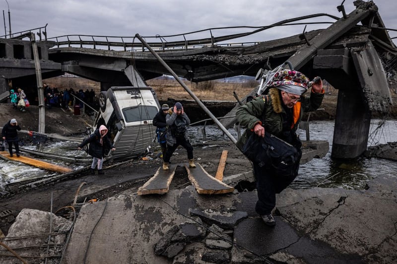 2022 年 3 月 7 日，乌克兰民众在撤离基辅西北部伊尔平市（Irpin）时穿过一座被毁坏的桥梁。 （法新社）