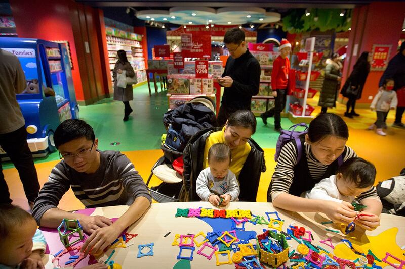 资料照：2017年12月23日，家长和孩子们在北京哈姆雷斯（Hamleys）玩具店开业活动中一起玩耍。（美联社）