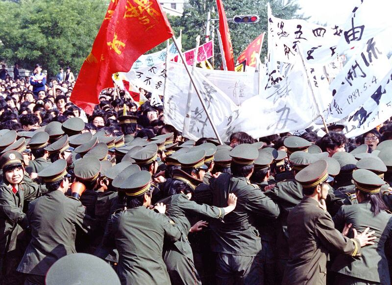 1989年5月4日，北京天安门广场附近，示威学生包围了警察，要求政府改革。（美联社）