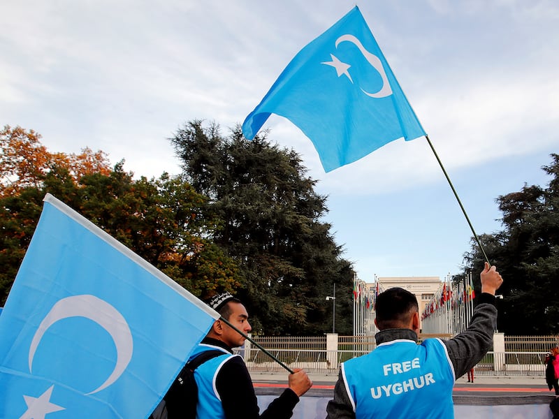 People wave Uyghur flags as they demonstrate against China in front of the United Nations Office in Geneva, Switzerland, Nov. 6, 2018.