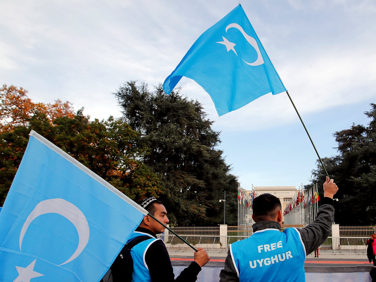 Uyghur -Aktivisten winken am 6. November 2018 gegen China vor dem Büro der Vereinten Nationen in Genf, Schweiz, die Flaggen der östlichen Turkestan, wie sie gegen China demonstrieren.