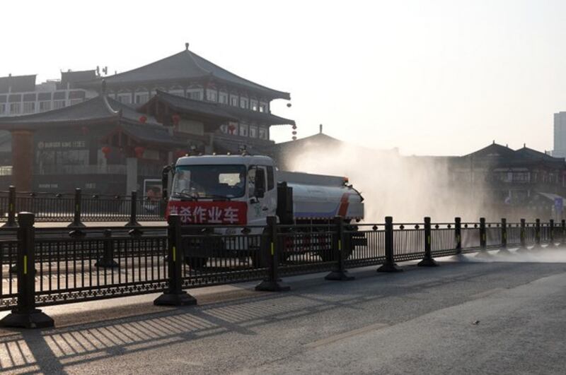 封城期间，一辆卡车2021年12月31日在西安街头进行消毒作业。（法新社）