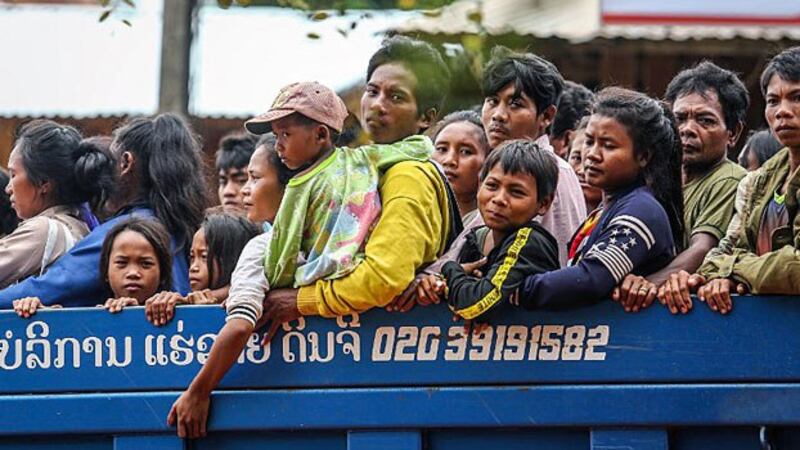 Lao villagers affected by widespread flooding caused by an auxiliary dam collapse at the Xe Pian Xe Namnoy hydropower project look out from the back of a truck as they are transported through a village in Sanamxai, southeastern Laos' Attapeu province, July 28, 2018.