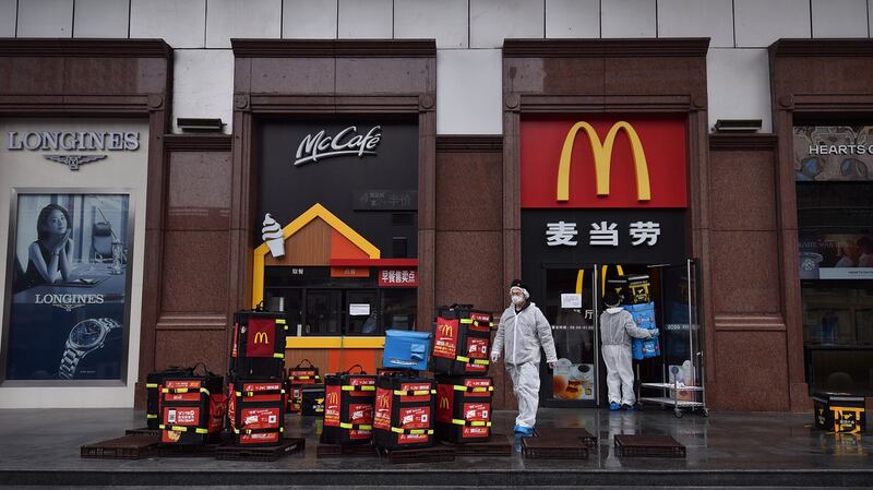 2020年2月26日，武汉的麦当劳工人在消毒，准备给居民送食物。（法新社）