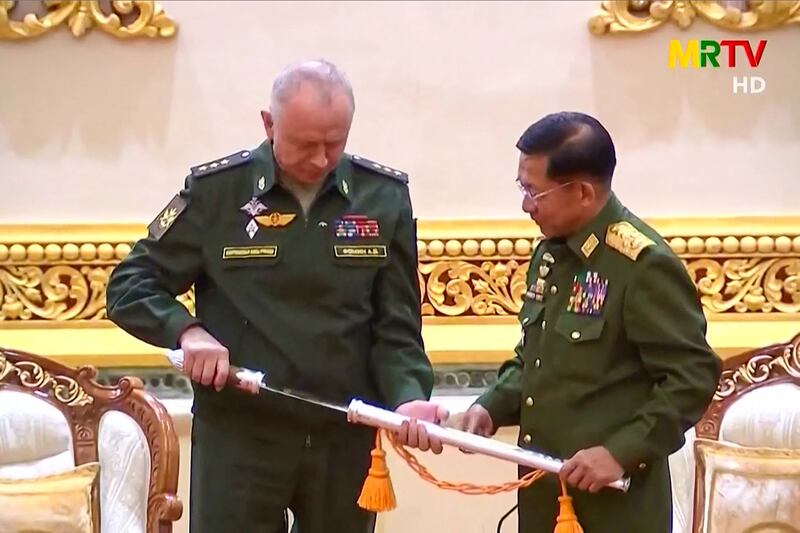 This screengrab provided via AFPTV and taken from a broadcast by Myanmar Radio and Television (MRTV) in Myanmar on March 26, 2021 shows Russia's Deputy Defense Minister Alexander Fomin (L) being presented with a sword by Myanmar armed forces chief Senior General Min Aung Hlaing in Naypyidaw. AFP