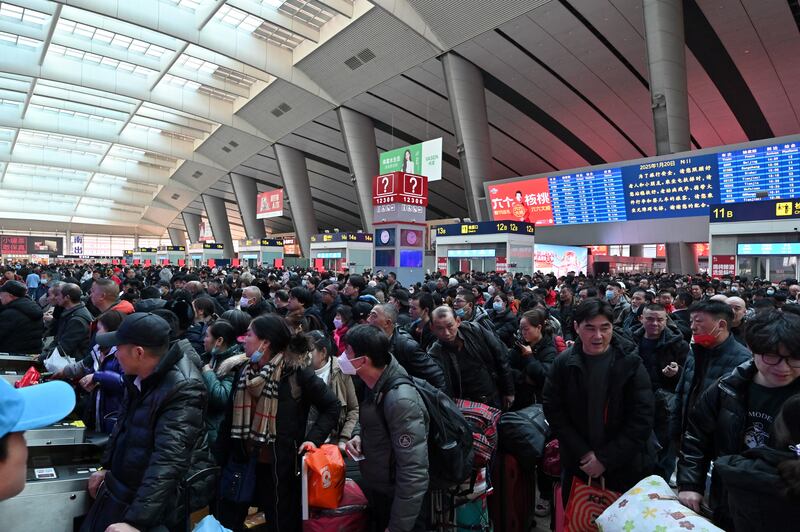 People buy tickets at a train station in Beijing as they return to their hometowns for Lunar New Year reunions, Jan. 20, 2025.