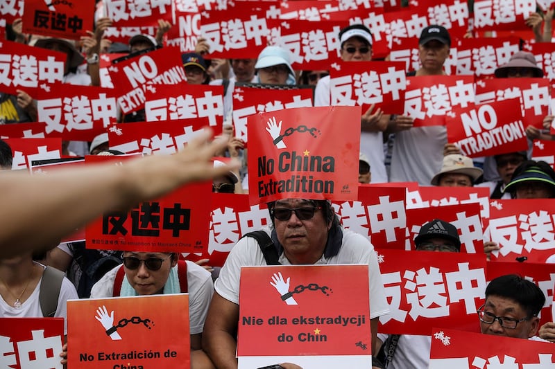 2019年6月9日，香港民间人权阵线举行反对修订《逃犯条例》的大游行，示威群众手持着“反送中”等标号。（美联社）