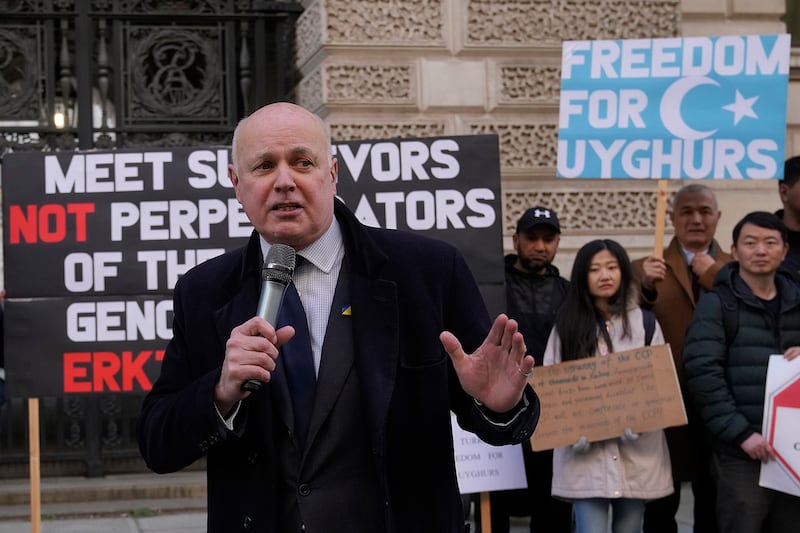 British lawmaker Iain Duncan Smith joins activists and community members as they hold a small protest outside the British Foreign Office in central London, Feb. 13, 2023.