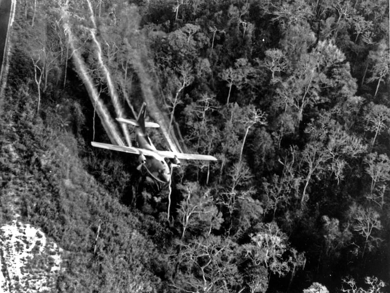 A U.S. Air Force C-123 flies low along a South Vietnamese highway spraying defoliants on jungle to eliminate ambush sites for the Viet Cong, May 1966, during the Vietnam War.