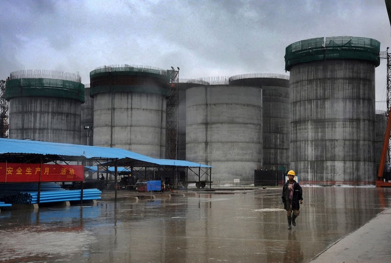 In this June 1, 2012 photo, a worker walks by the oil tanks that are under construction at a site operated by China National Petroleum Corporation at an offshore block of Madae Island near Kyauk Phyu, Rakhine state, Myanmar. Credit: Lwin Ko Taik/AFP