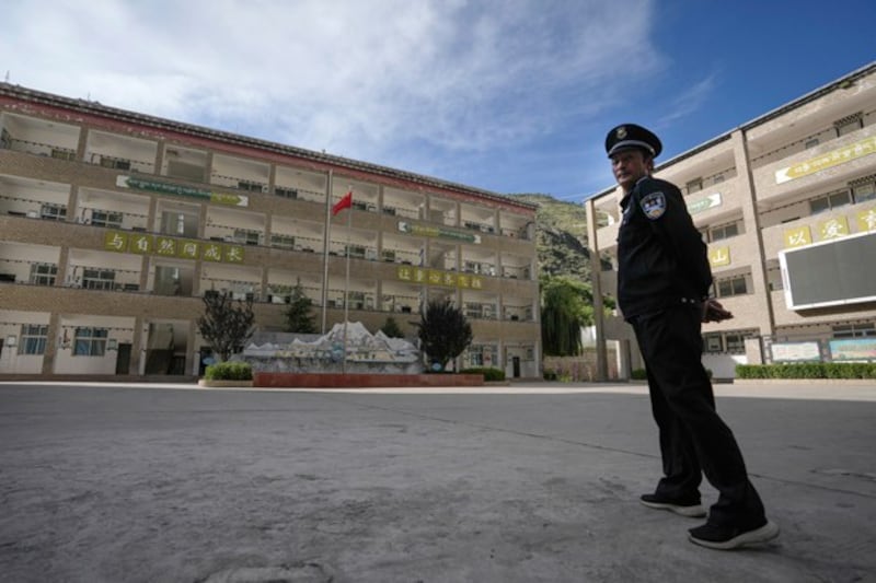 A security guard stands watch at the Shangri-La Key Boarding School during a media-organized tour in Dabpa county, Kardze prefecture, southwestern China's Sichuan province, Sept. 5, 2023. (Andy Wong/AP)